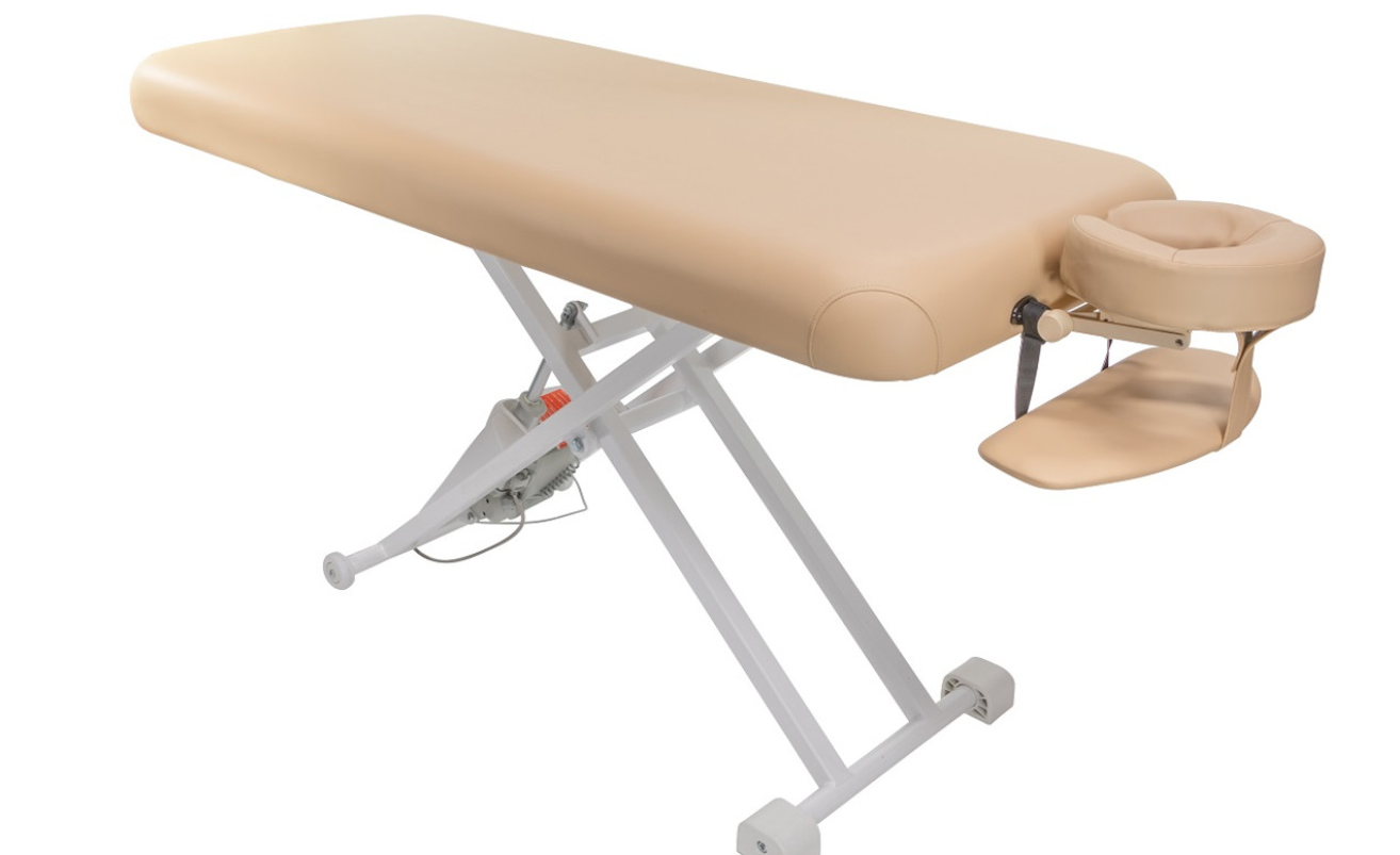Cream portable massage table with adjustable metal frame.